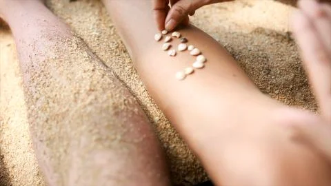 Female hands collect pattern of shells and sand, close up. Video. Pieces of Stock Photos