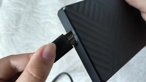 Female hands connect the cable to an external HDD hard drive. Additional memory Stock Footage 313980090