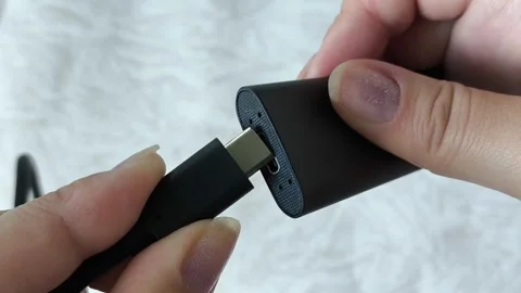 Female hands connect the cable to an external SSD drive. Hard drive, memory card Video stock 313980210