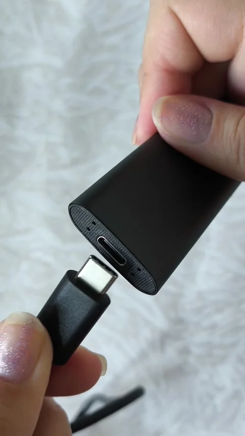 Female hands connect the cable to an external SSD drive. Hard drive, memory card Stock Footage 313980286