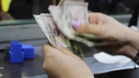Female Hands Count U.S. Dollars After Receiving Colombian Pesos Stock Footage 168333813