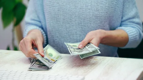 Female hands counting a stack of hundred dollar banknotes in the office. Stock Footage 240304249