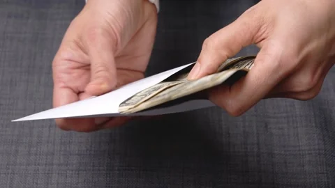 Female hands counting US dollars bills in white envelope. Saving money, family Stock Footage 153602914