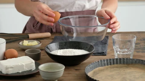 Female hands crack egg. Breaking an egg. Greek cheese pie. A woman prepares a Stock Footage 141358332