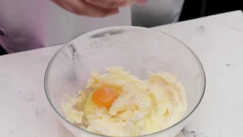Female hands cracking egg into dough 動画素材 267003182