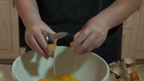Female hands cracking eggs into mixing bowl Stock Footage 342361692