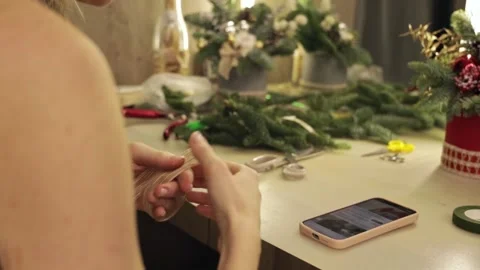 Female hands create Christmas composition. Learning to tie a bow Stock Footage 223734115