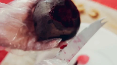 Female hands cut the beetroot on a kitchen board with a knife, lens distortion Stock Footage 233107490