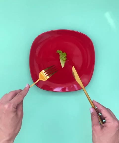 Female hands cut a leaf of greens with cutlery, the concept of weight loss,.. Stock Footage 277936387