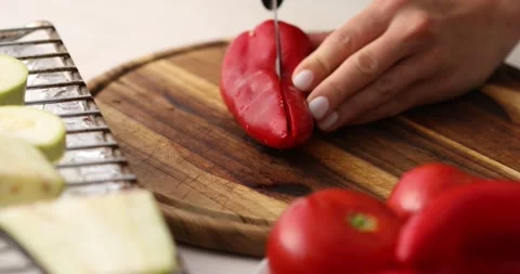 Female hands cut sweet Red Bell Pepper on a cutting board. Stock Footage 250020122
