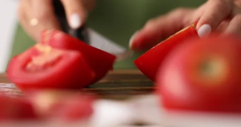 Female hands cut tomato on a cutting board. Stock Footage 250019981