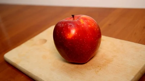 Female hands cut into two halves of an apple. Video stock 127321830