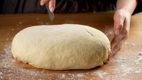 Female hands cutting bread dough with a sharp blade close-up in slow motion 4K Stock Footage 266221579