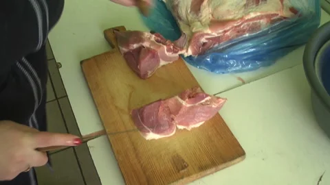 Female hands cutting meat on the table in the dining room. Vídeo Stock 308825871