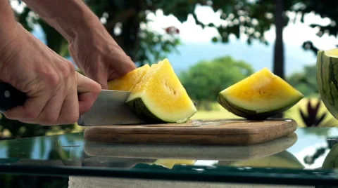 Female hands cutting melon on table in the garden, super slow motion Stock Footage 67504564