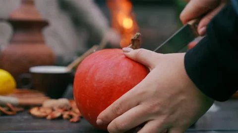 Female hands cutting pumpkin on table with knife leaving with vegetable. Young Stock Footage 237518334
