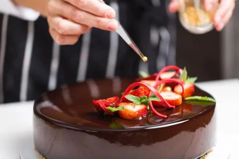 Female hands decorating cake Stock Photos