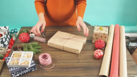 Female hands decorating gift red boxes for Christmas Holiday. Hands close up. Stock Footage 97930488