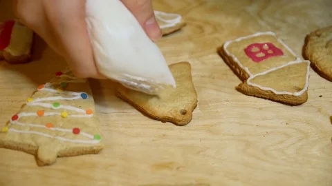 Female hands decorating gingerbread bell with icing sugar using selfmade past Stock Footage 69807891