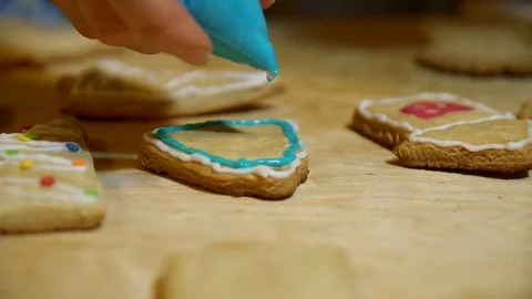 Female hands decorating gingerbread bell with icing sugar using selfmade pastry Stock Footage 69808634