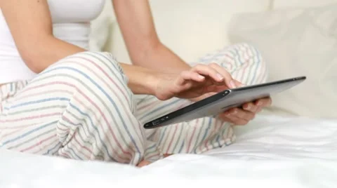 Female hands with digital tablet in bed, dolly shot HD Stock Footage 10307639