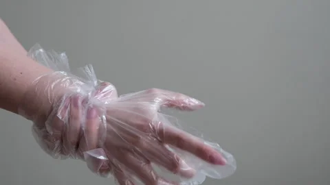 Female hands with disposable plastic gloves on gray background environmental Stock Footage 346190238