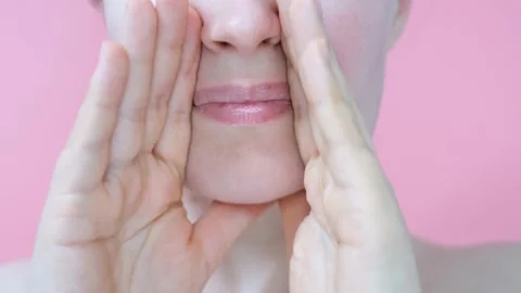 Female hands do self-massage of the face close-up on pink background. Stock Footage 169590386