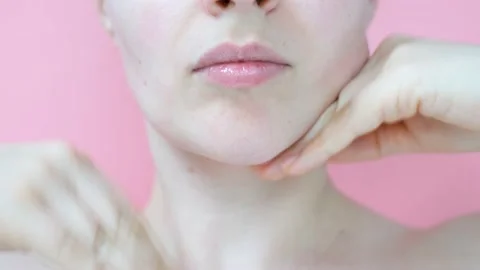 Female hands do self-massage of neck close-up on pink background. Stock Footage 169913660