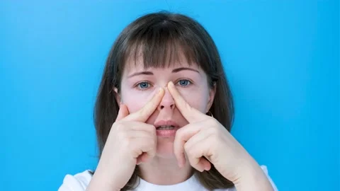 Female hands do self-massage of the face close-up on blue background. Stock Footage 169914231