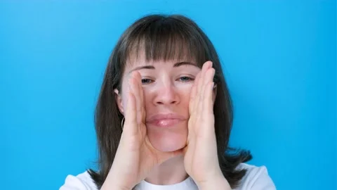 Female hands do self-massage of face close-up on blue background. Stock Footage 170118719