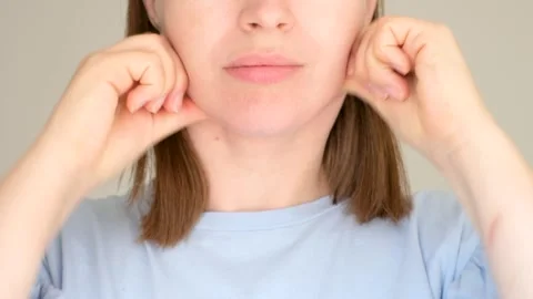 Female hands do self-massage of face close-up on gray background. Stock Footage 249990732
