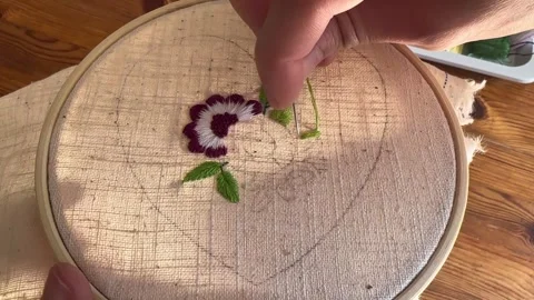 Female hands doing hand embroidery stitching of leaves with green thread Stock Footage 335193839