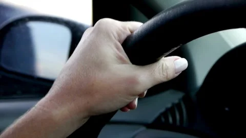 Female hands of the driver on the steering wheel while driving a car on asphalt Stock-Footage 336266368