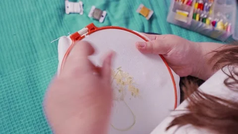 Female hands embroider a pattern on the hoop. needle and thread embroidery. hand Stock Footage 219851242