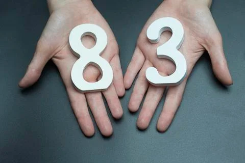 To female hands the figure of eighty-three. Stock Photos
