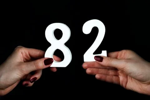 To female hands the figure of eighty-two. Stock Photos
