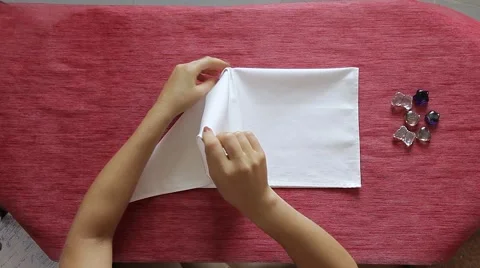 Female hands folding white textile napkin like a pavilion. Table decoration. Stock Footage 64543903