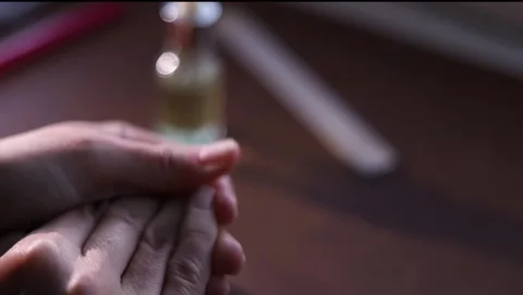 Female hands gently rub together, applying skincare in soft indoor light, s.. Stock Footage 333845267