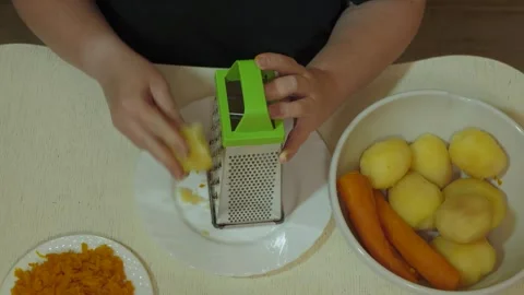 Female hands grating boiled potato over white plate Vidéo 342362178