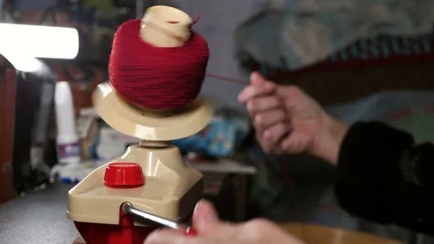 Female hands on hand winding machine winding a new skein of red yarn. Stock Footage 305162963
