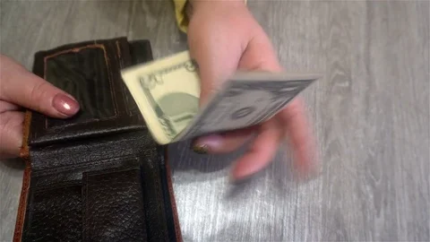 Female hands hold dollar bills from her purse and puts them back into the purse Stock Footage 83286653