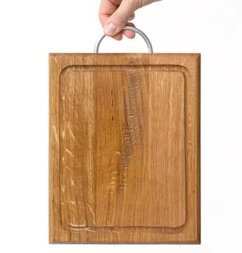 Female hands hold empty rectangular brown wooden chopping board on white back 스톡 사진