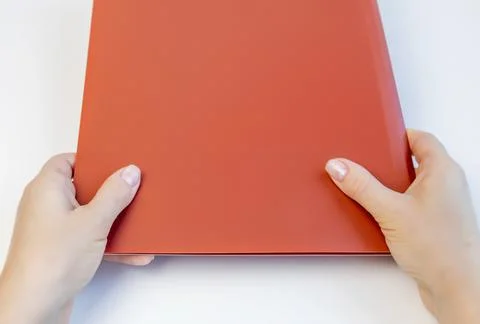 Female hands hold a folder for documents above the table. Stock Photos