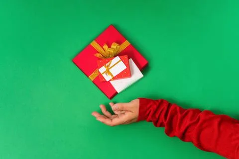Female hands hold levitating different gift boxes and a bonus or gift card Stock Photos