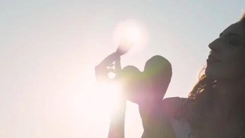 Female hands hold red soft hearts on sunset background close-up. Valentine's Day Stock-Footage 153105045