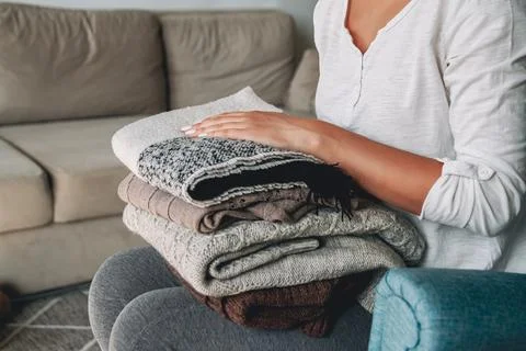 Female hands hold a stack of warm knitted sweaters Stock-Fotos