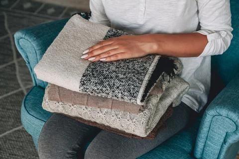 Female hands hold a stack of warm knitted sweaters Stock Photos