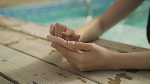 Female hands holding and using smartphone next to swimming pool during vacation Stock Footage 140767277