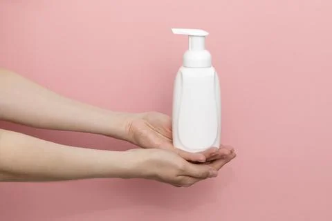 Female Hands Holding Blank White Dispenser Bottle, Plastic Tube On Pink Stock Photos