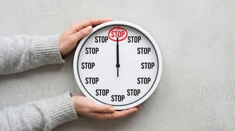 Female Hands Holding Clock with STOP Text Bad Habit Control Concept Stock Photos